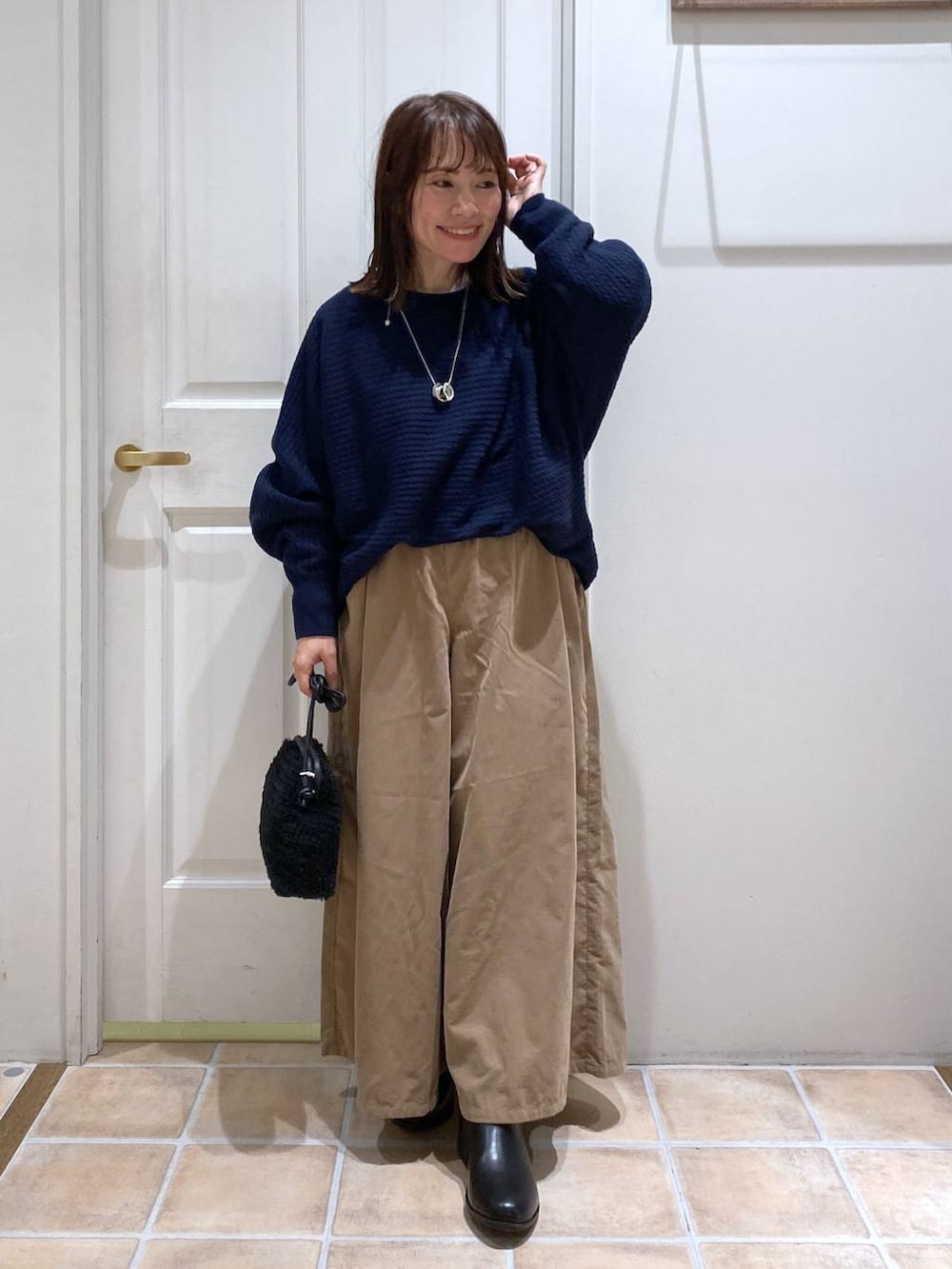 ベージュ系のその他パンツ、ブラック系のブーツ、ブルー系のニット/セーターを着用したレディースの秋コーディネートの3枚目の写真