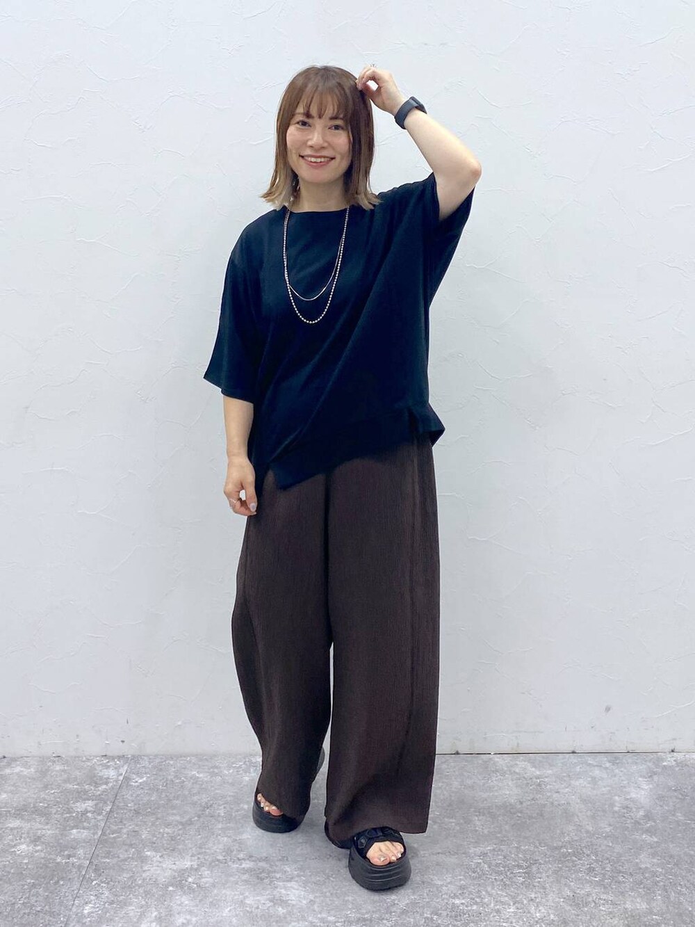 ブラック系のサンダルを着用したレディースの夏コーディネートの2枚目の写真