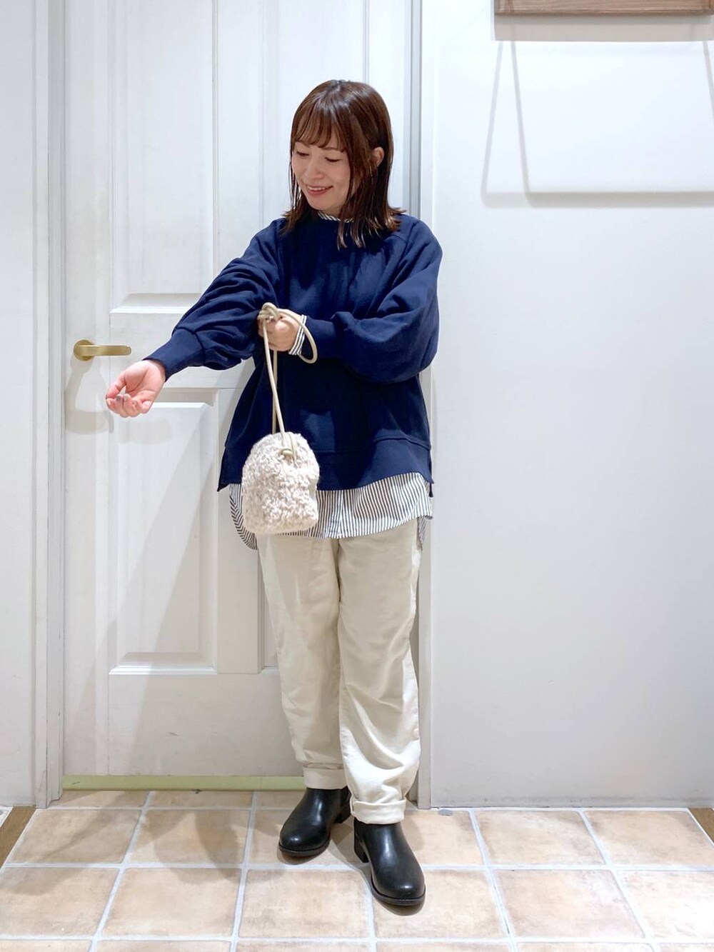 ブルー系のスウェット、ホワイト系のその他パンツ、ブラック系のブーツを着用したレディースの秋コーディネートの5枚目の写真