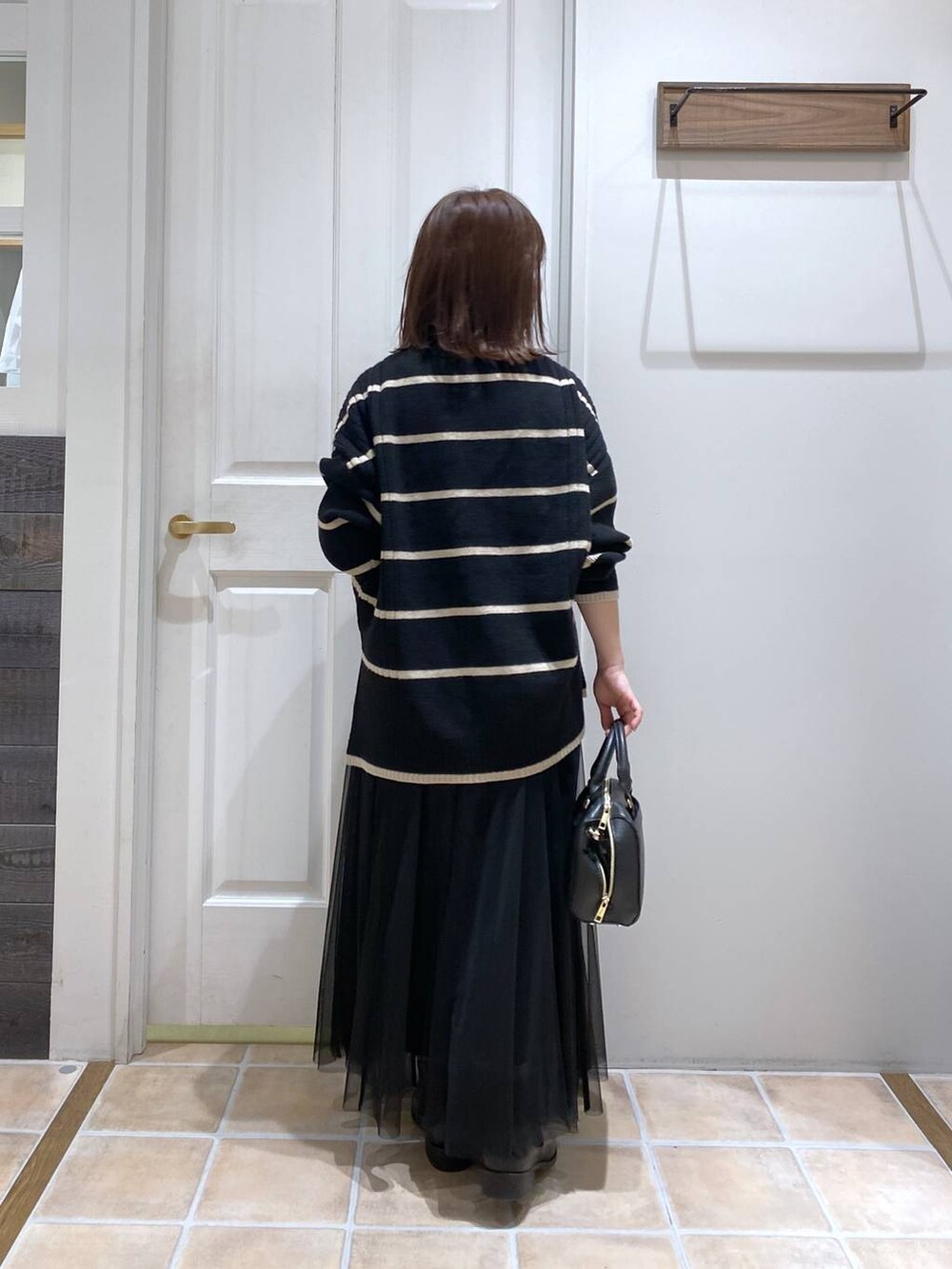 ブラック系のブーツ、その他のニット/セーター、ブラック系のスカートを着用したレディースの冬コーディネートの6枚目の写真