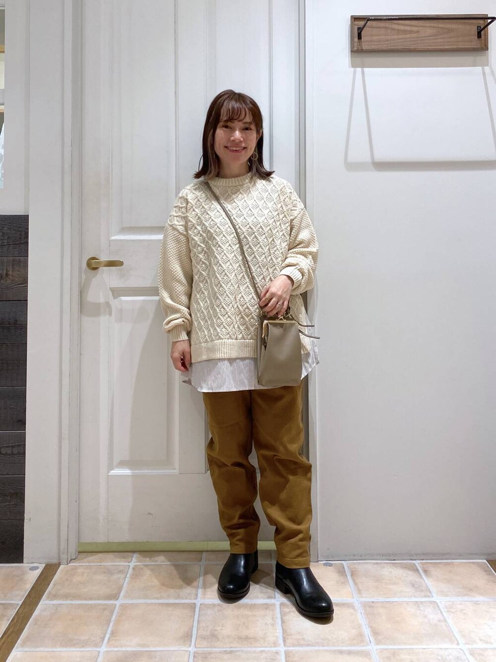 ブラック系のブーツ、イエロー系のその他パンツ、ベージュ系のニット/セーターを着用したレディースの冬コーディネートの3枚目の写真