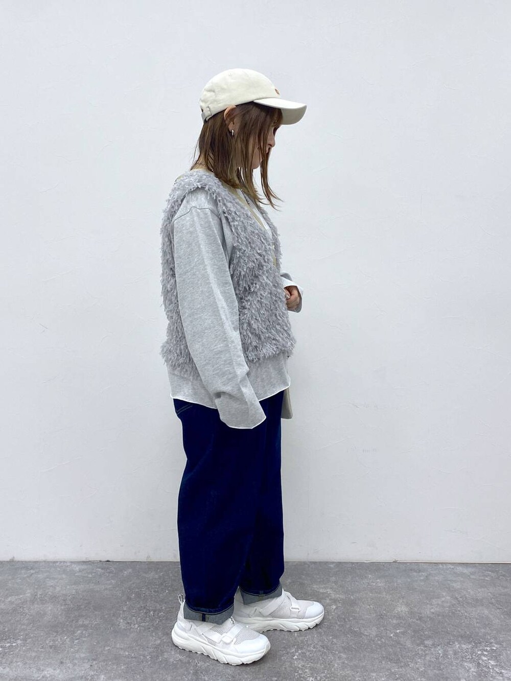 ブルー系のデニムパンツ、グレー系のベスト、グレー系のTシャツ/カットソーを着用したレディースの春コーディネートの3枚目の写真