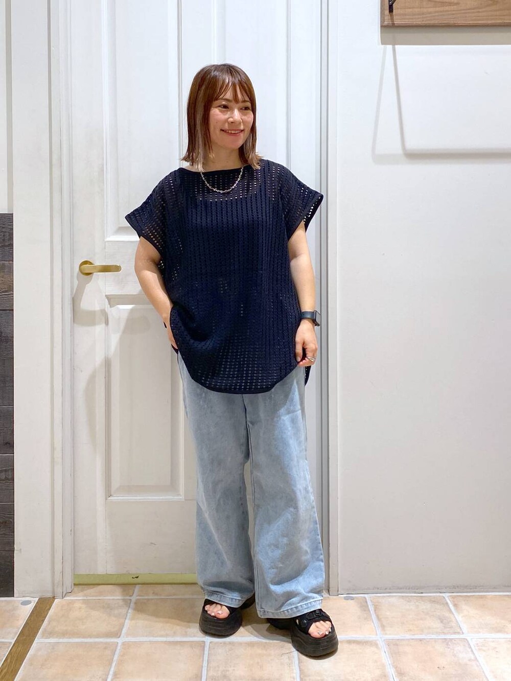 ブラック系のサンダル、ブルー系のデニムパンツ、ブラック系のTシャツ/カットソーを着用したレディースの夏コーディネートの2枚目の写真