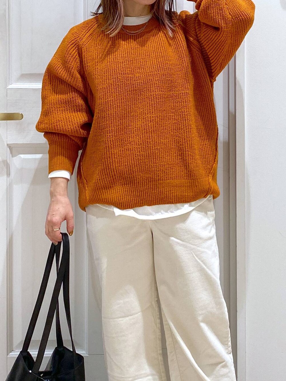 ベージュ系のその他パンツ、ブラック系のブーツ、オレンジ系のニット/セーターを着用したレディースの秋コーディネートの4枚目の写真