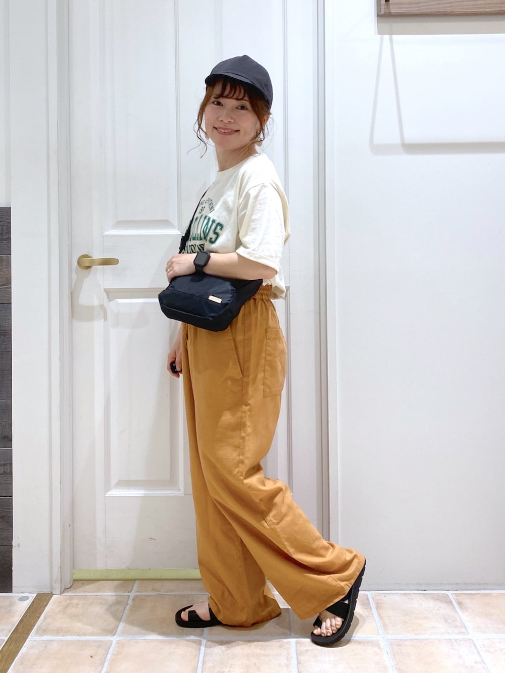 ベージュ系のTシャツ/カットソー、イエロー系のその他パンツ、ブラック系のショルダーバッグを着用したレディースの春コーディネートの3枚目の写真