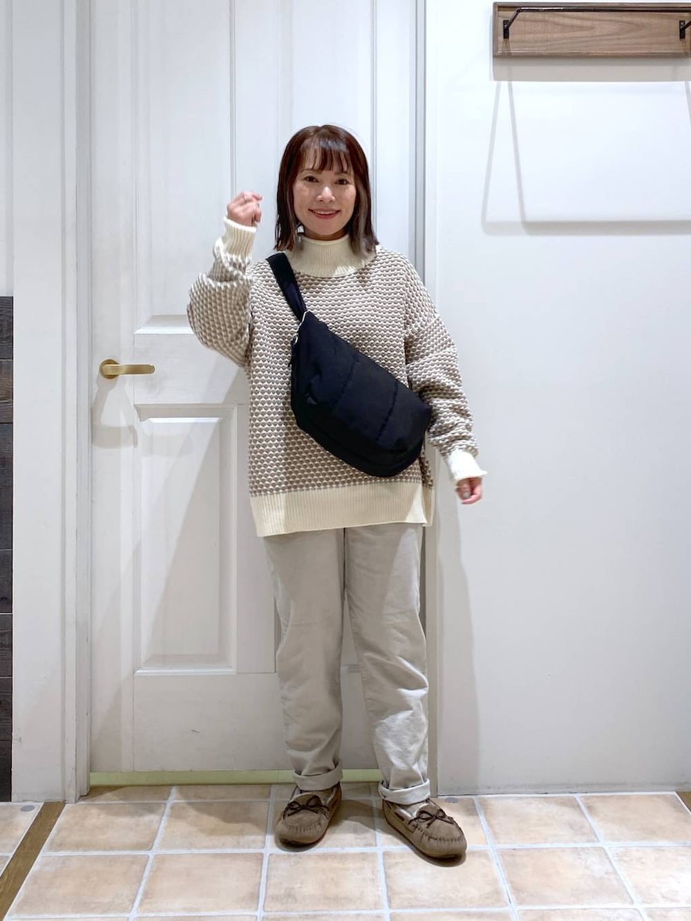 グレー系のその他パンツ、ホワイト系のニット/セーター、グレー系のモカシン/デッキシューズを着用したレディースの秋コーディネートの4枚目の写真