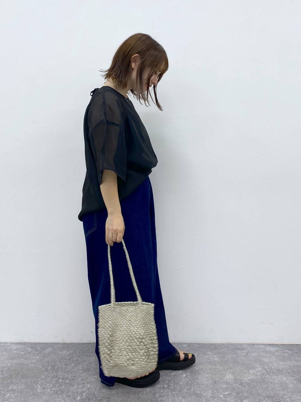 ブラック系のTシャツ/カットソー、ブラック系のサンダル、その他のハンドバッグを着用したレディースの夏コーディネートの5枚目の写真