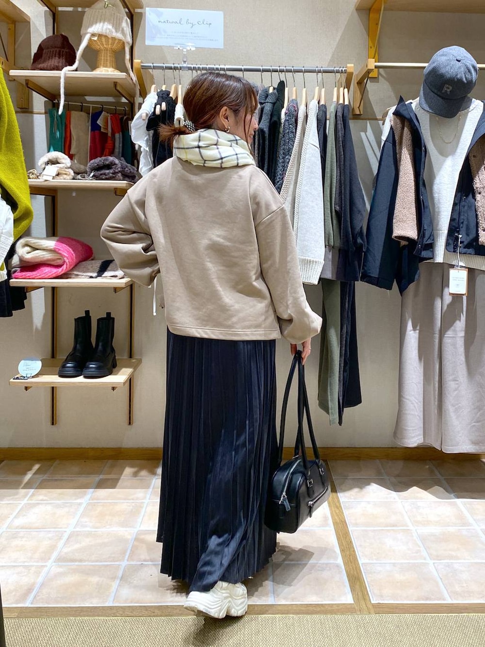 グレー系のスカート、ブラック系のトートバッグ、ベージュ系のTシャツ/カットソーを着用したレディースの冬コーディネートの6枚目の写真