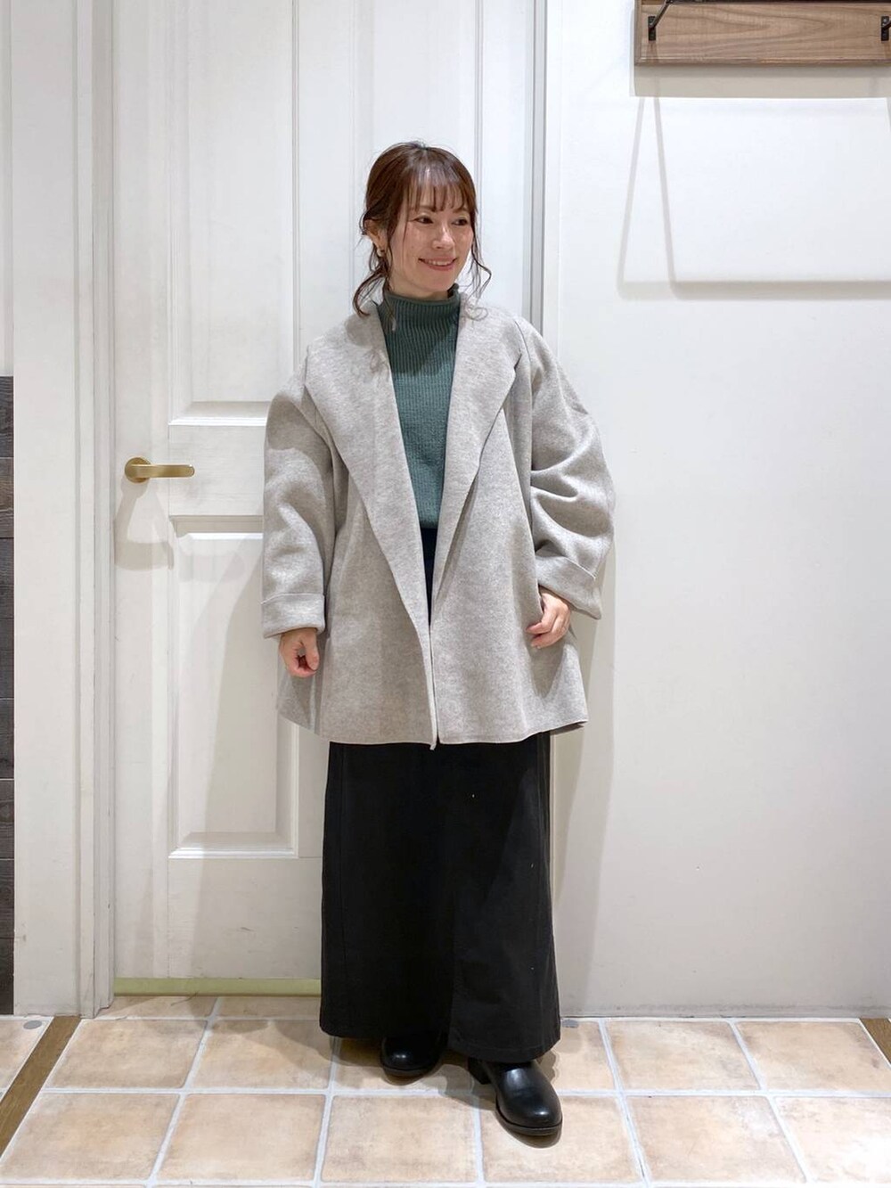 ブラック系のスカート、グレー系のテーラードジャケット、ブラック系のブーツを着用したレディースの秋コーディネートの2枚目の写真