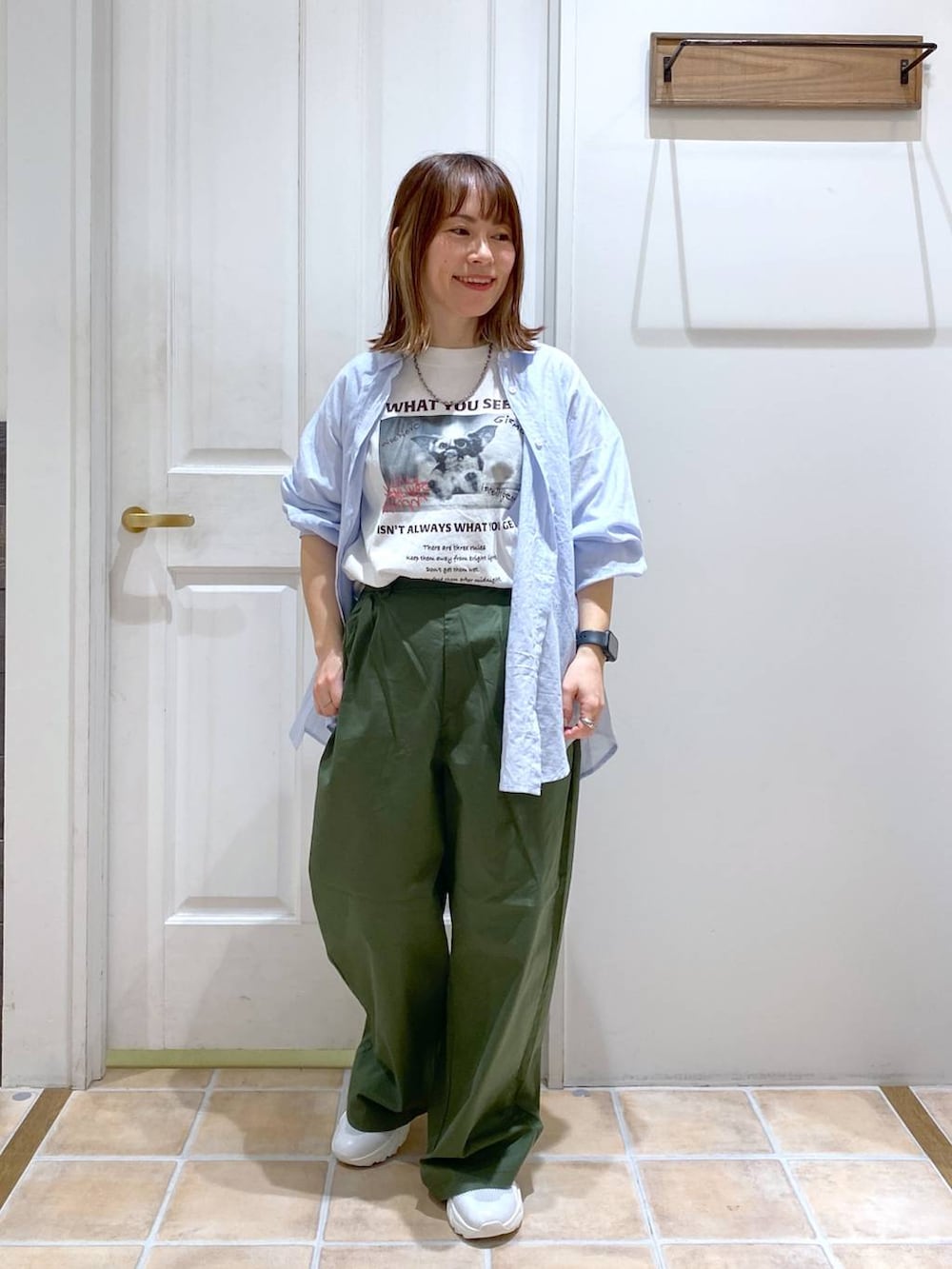ホワイト系のスニーカー、その他のシャツ/ブラウス、グリーン系のチノパンツを着用したレディースの春コーディネートの2枚目の写真