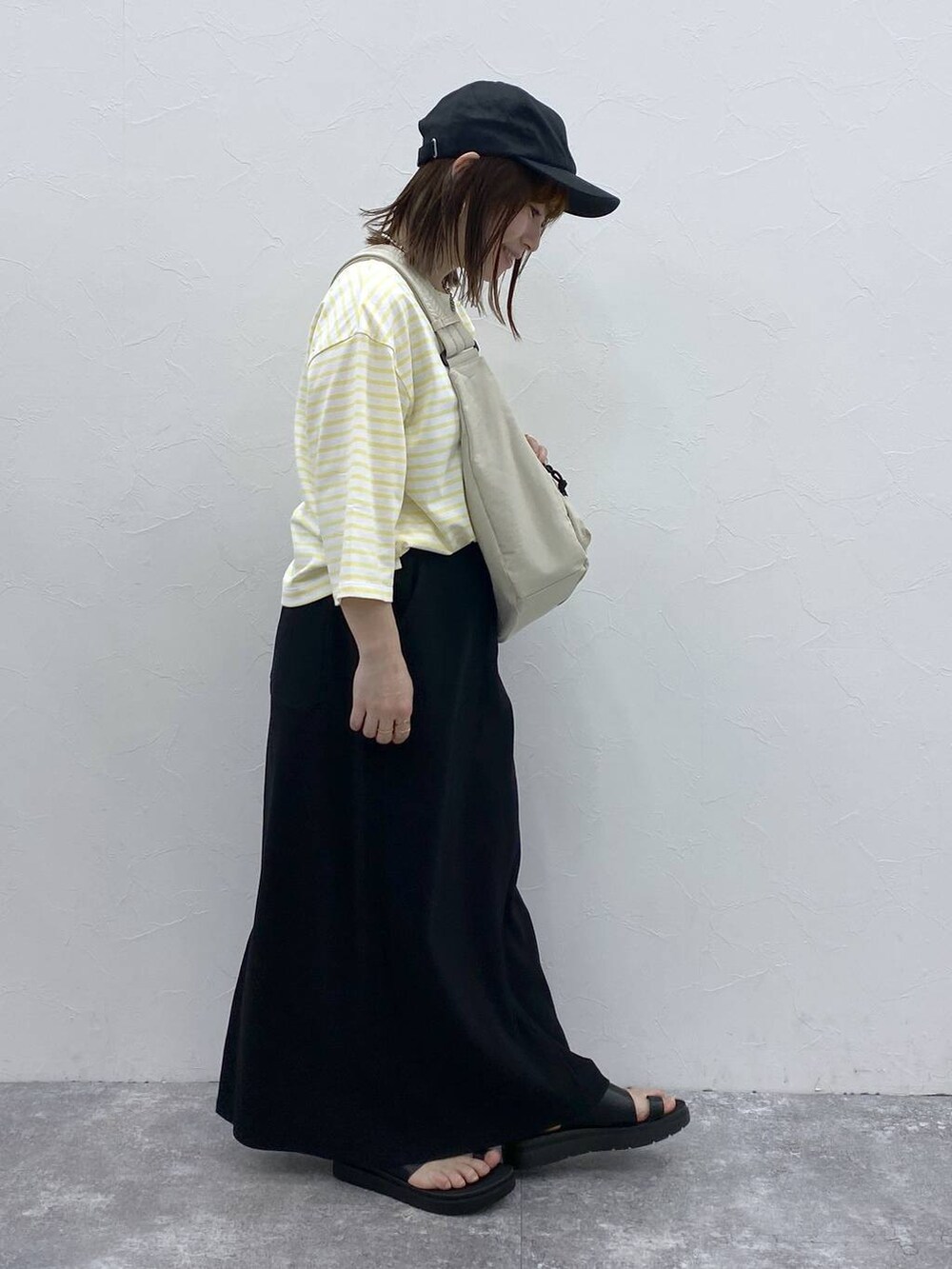 ホワイト系のショルダーバッグ、ブラック系のスカート、シルバー系のネックレスを着用したレディースの春コーディネートの5枚目の写真