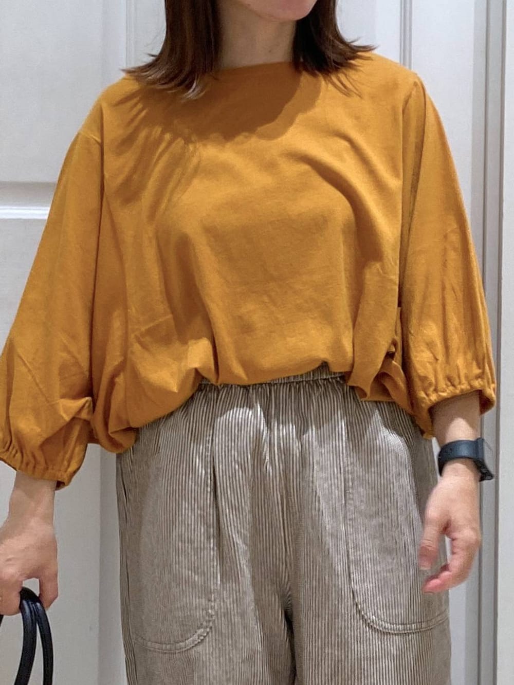 オレンジ系のTシャツ/カットソー、ブラック系のキャミソール、その他のデニムパンツを着用したレディースの夏コーディネートの3枚目の写真