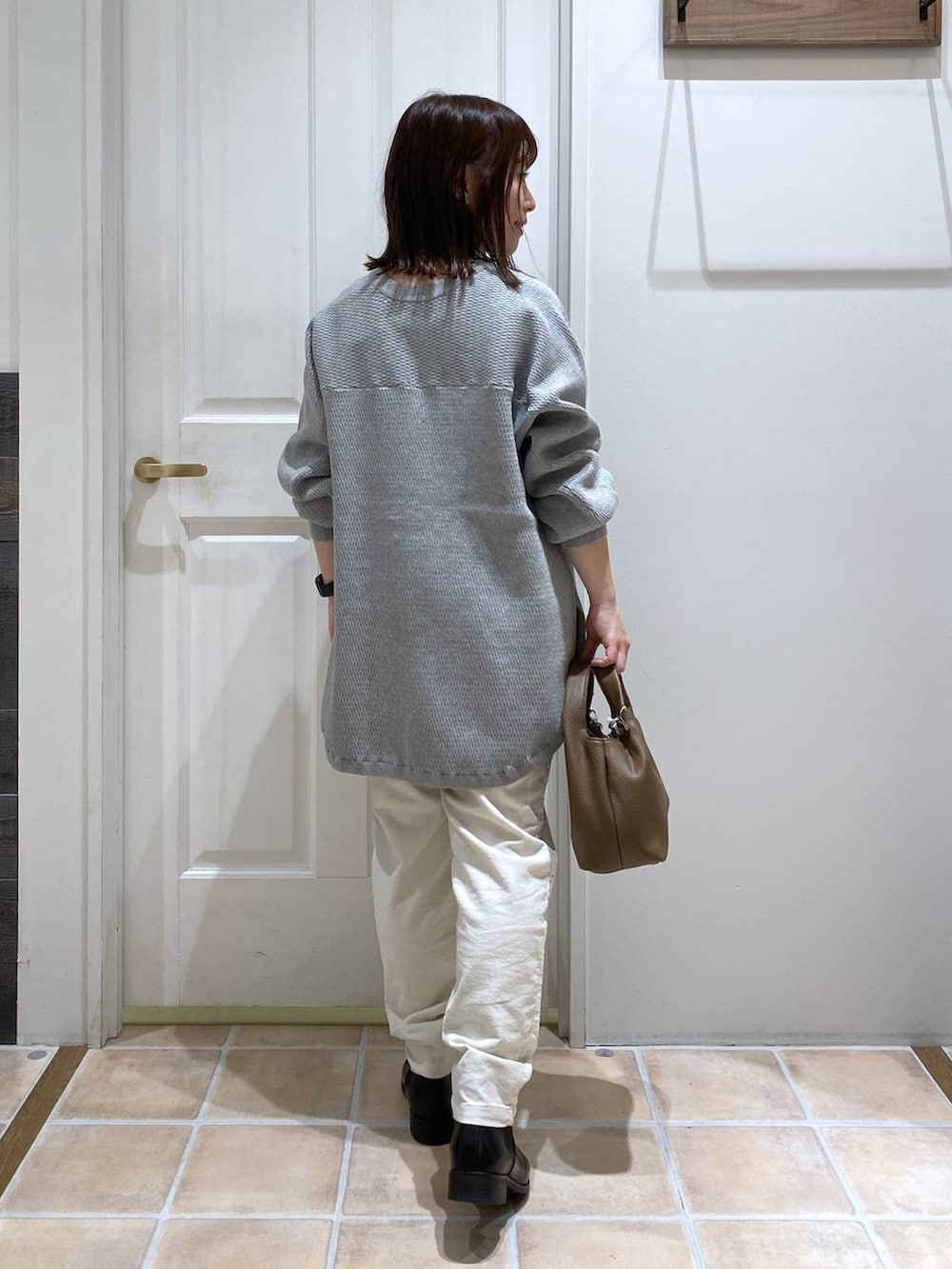 ホワイト系のその他パンツ、ブラック系のブーツ、ブラウン系のショルダーバッグを着用したレディースの秋コーディネートの6枚目の写真