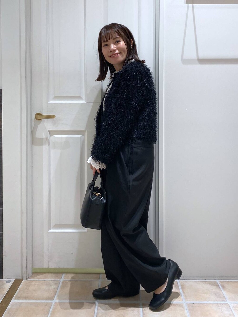 ブラック系のサロペット/オーバーオール、ブラック系のパンプス、ホワイト系のシャツ/ブラウスを着用したレディースの秋コーディネートの6枚目の写真