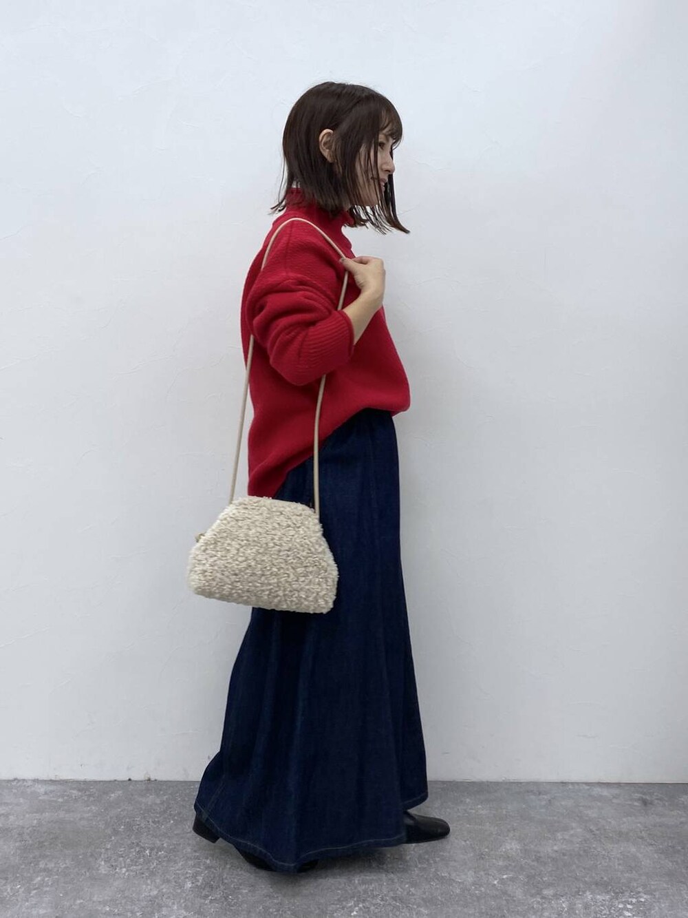 ブルー系のデニムパンツ、ブラック系のブーツを着用したレディースの秋コーディネートの6枚目の写真