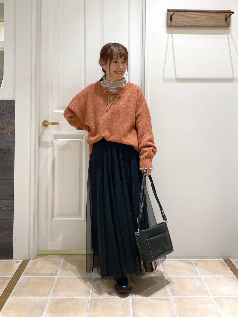 その他のTシャツ/カットソー、ブラック系のブーツ、オレンジ系のニット/セーターを着用したレディースの冬コーディネートの2枚目の写真