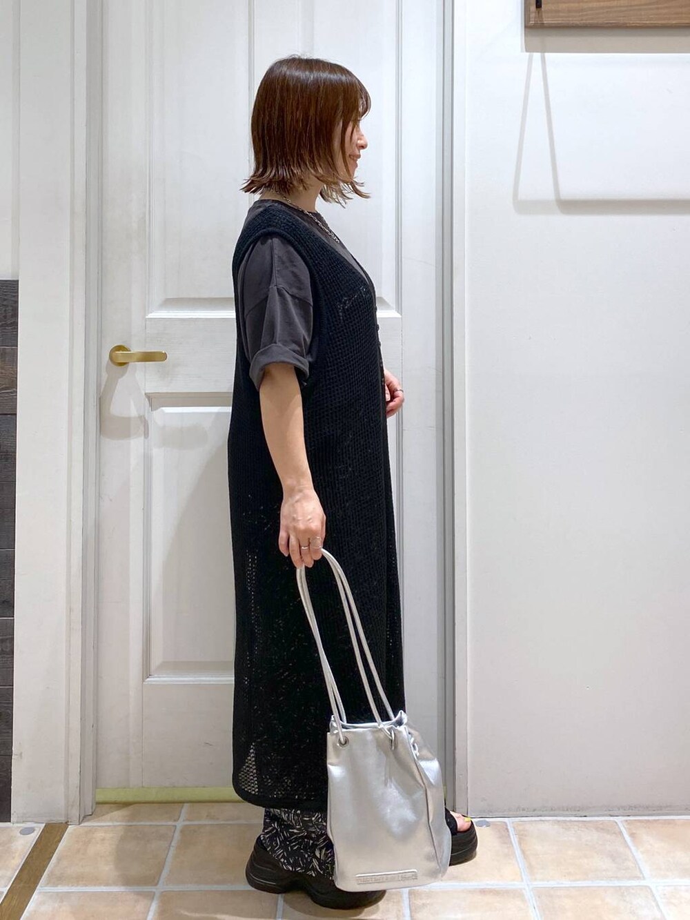 ブラック系のサンダル、ホワイト系のタンクトップ、その他のトートバッグを着用したレディースの夏コーディネートの4枚目の写真