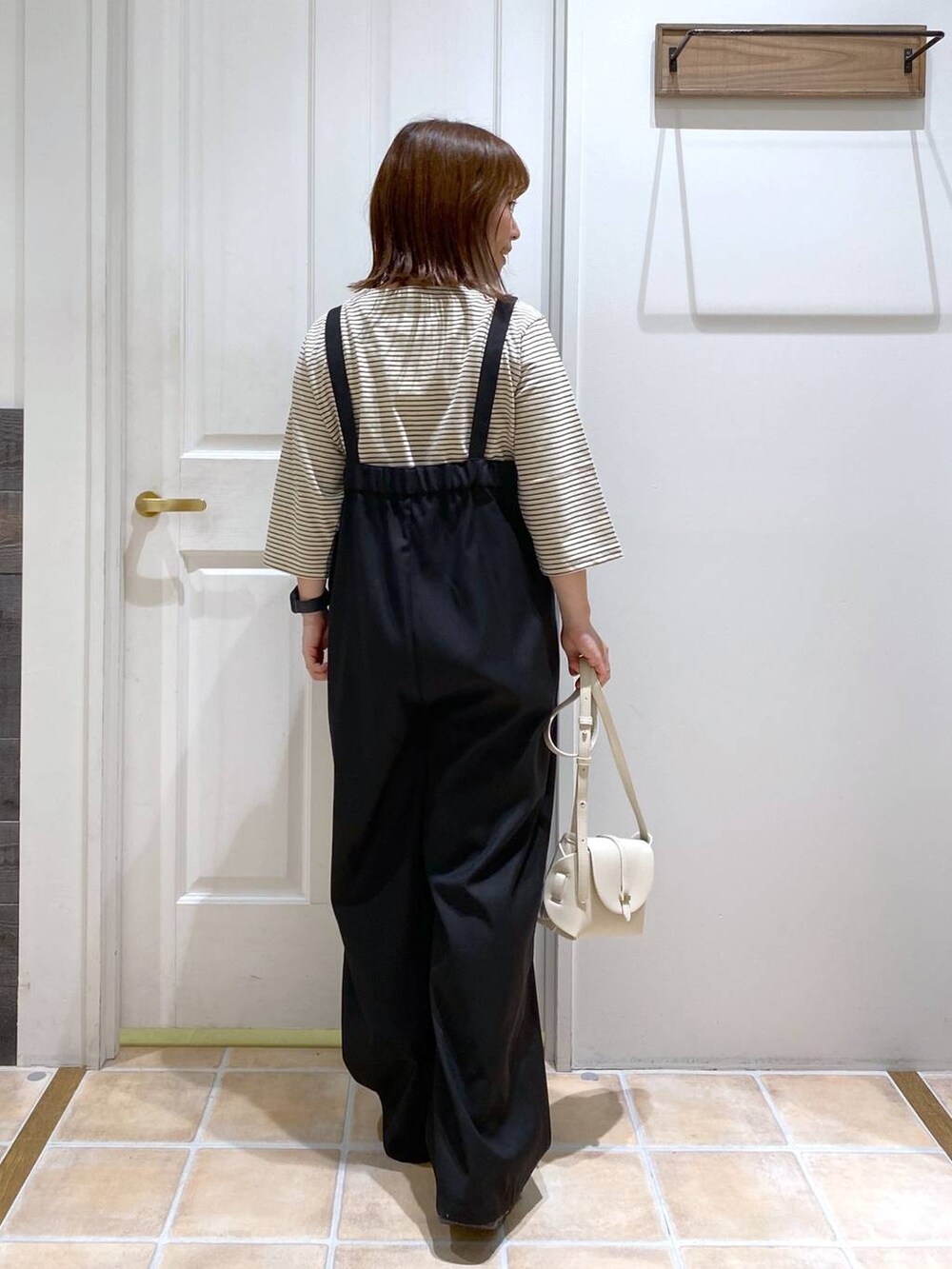 ブラック系のサンダル、ホワイト系のショルダーバッグ、シルバー系のネックレスを着用したレディースの夏コーディネートの6枚目の写真