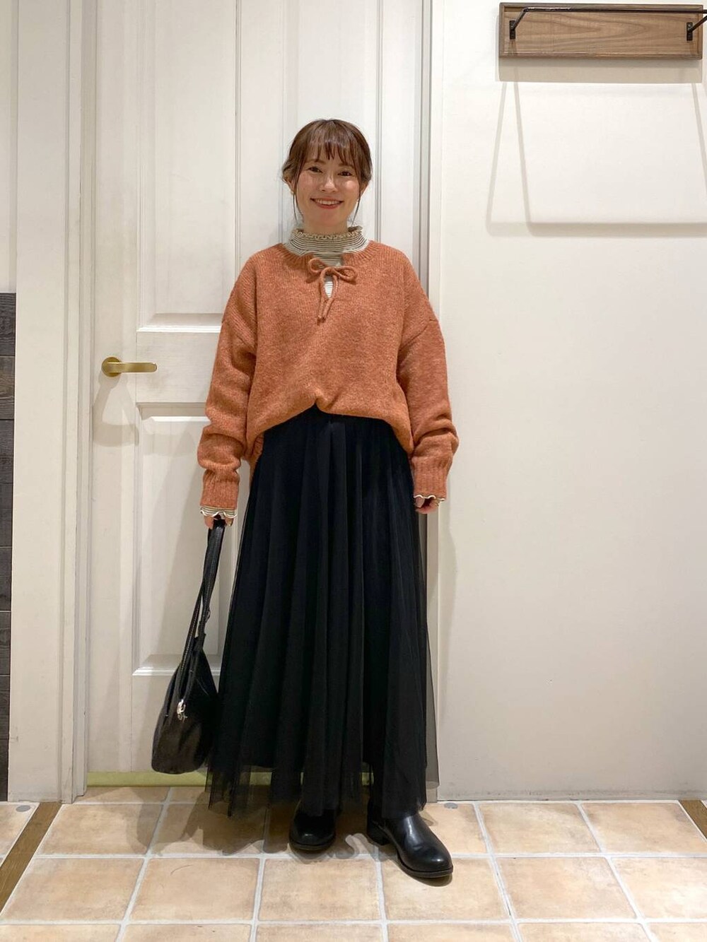 その他のTシャツ/カットソー、ブラック系のブーツ、オレンジ系のニット/セーターを着用したレディースの冬コーディネートの3枚目の写真