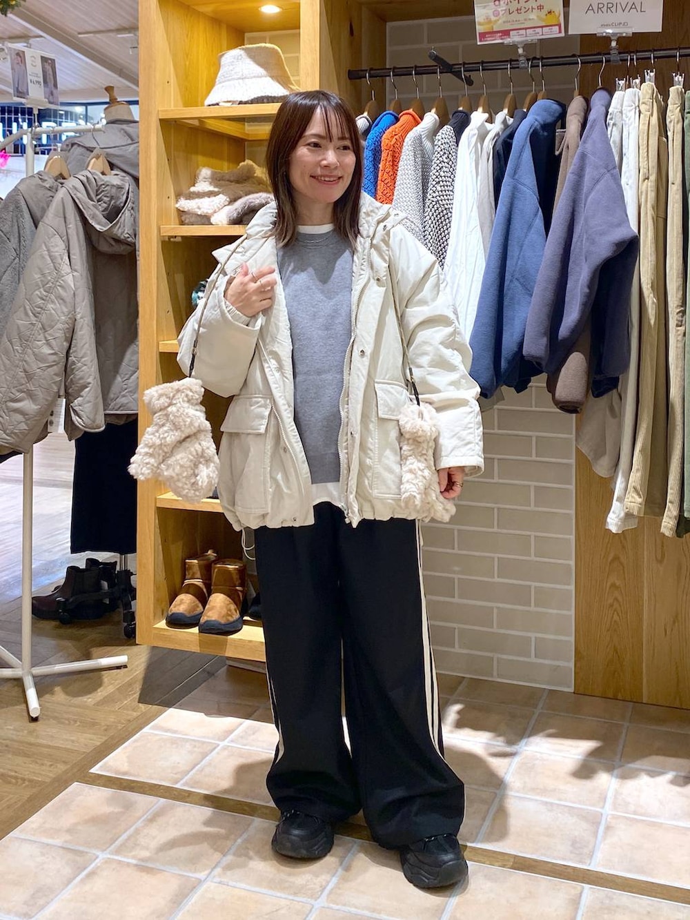 ベージュ系のブルゾン、グレー系のニット/セーター、ホワイト系のTシャツ/カットソーを着用したレディースの冬コーディネートの2枚目の写真