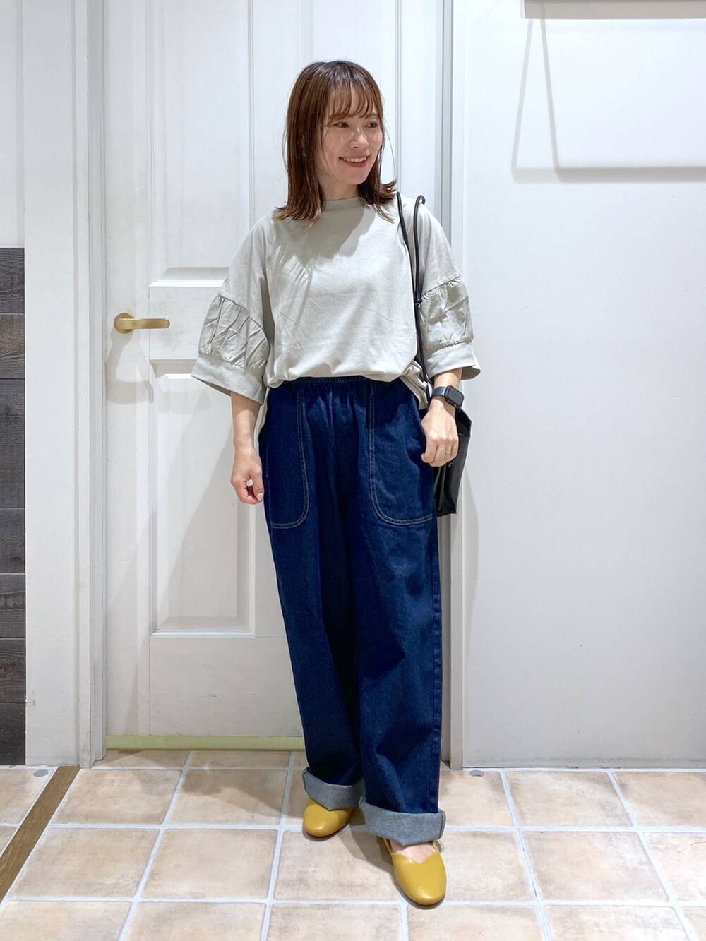 ベージュ系のタンクトップ、ブルー系のデニムパンツ、グリーン系のTシャツ/カットソーを着用したレディースの夏コーディネートの2枚目の写真