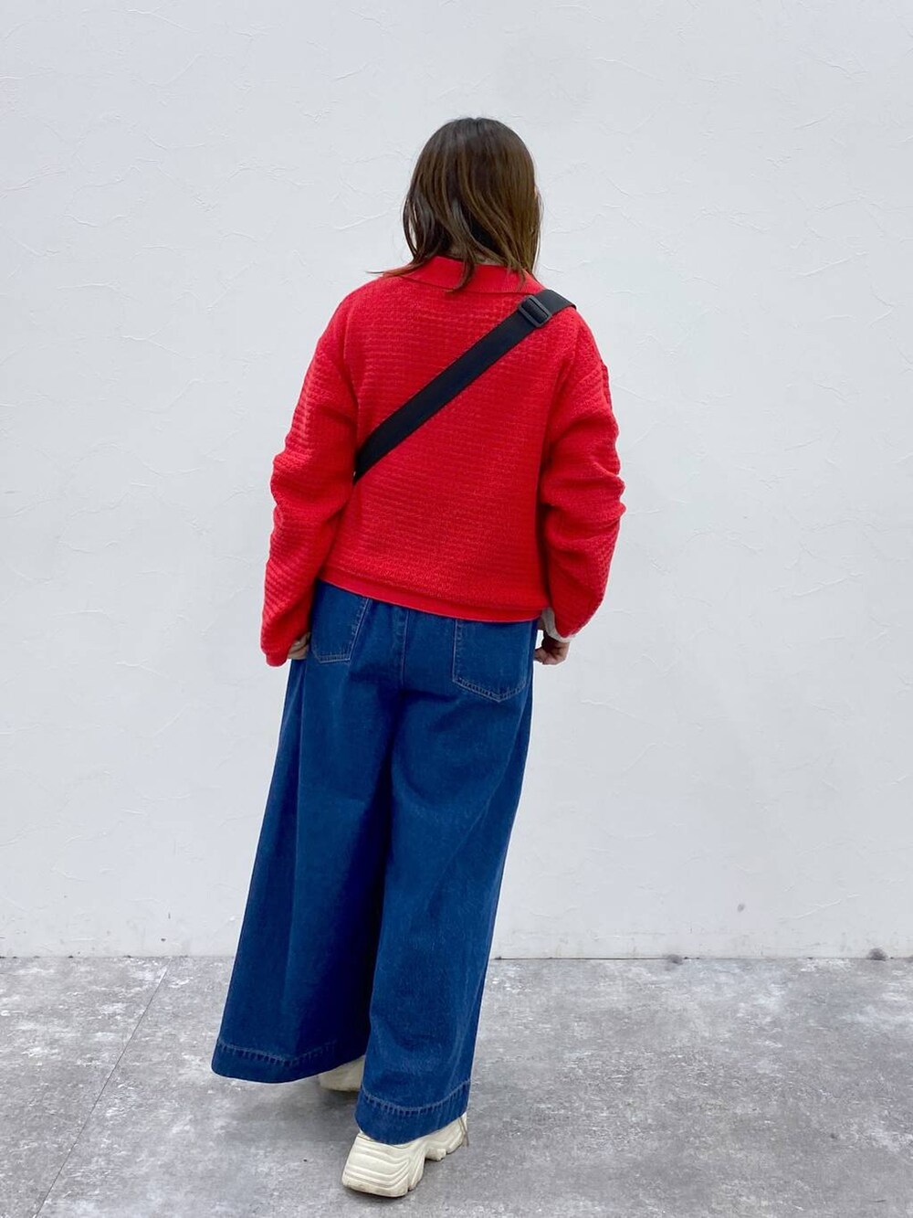 ベージュ系のショルダーバッグ、ブルー系のデニムパンツ、レッド系のカーディガン/ボレロを着用したレディースの春コーディネートの5枚目の写真