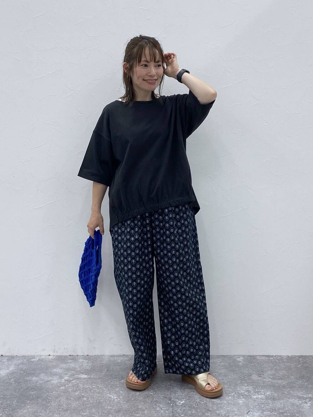 ゴールド系のサンダル、ブラック系のその他パンツ、ブラック系のTシャツ/カットソーを着用したレディースの夏コーディネートの2枚目の写真