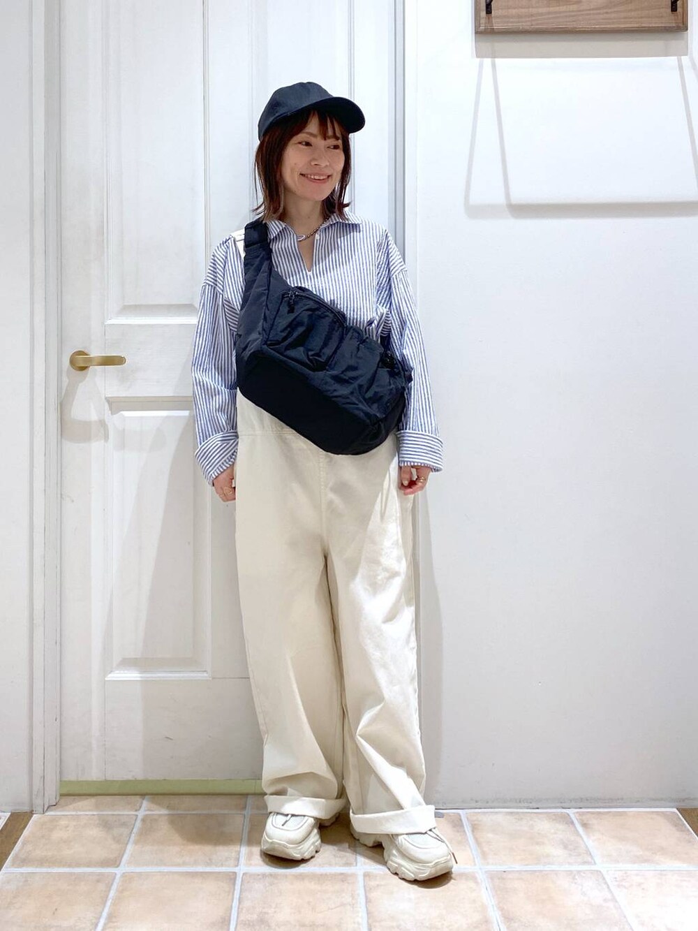 ブラック系のショルダーバッグ、その他のシャツ/ブラウス、ホワイト系のスニーカーを着用したレディースの春コーディネートの2枚目の写真