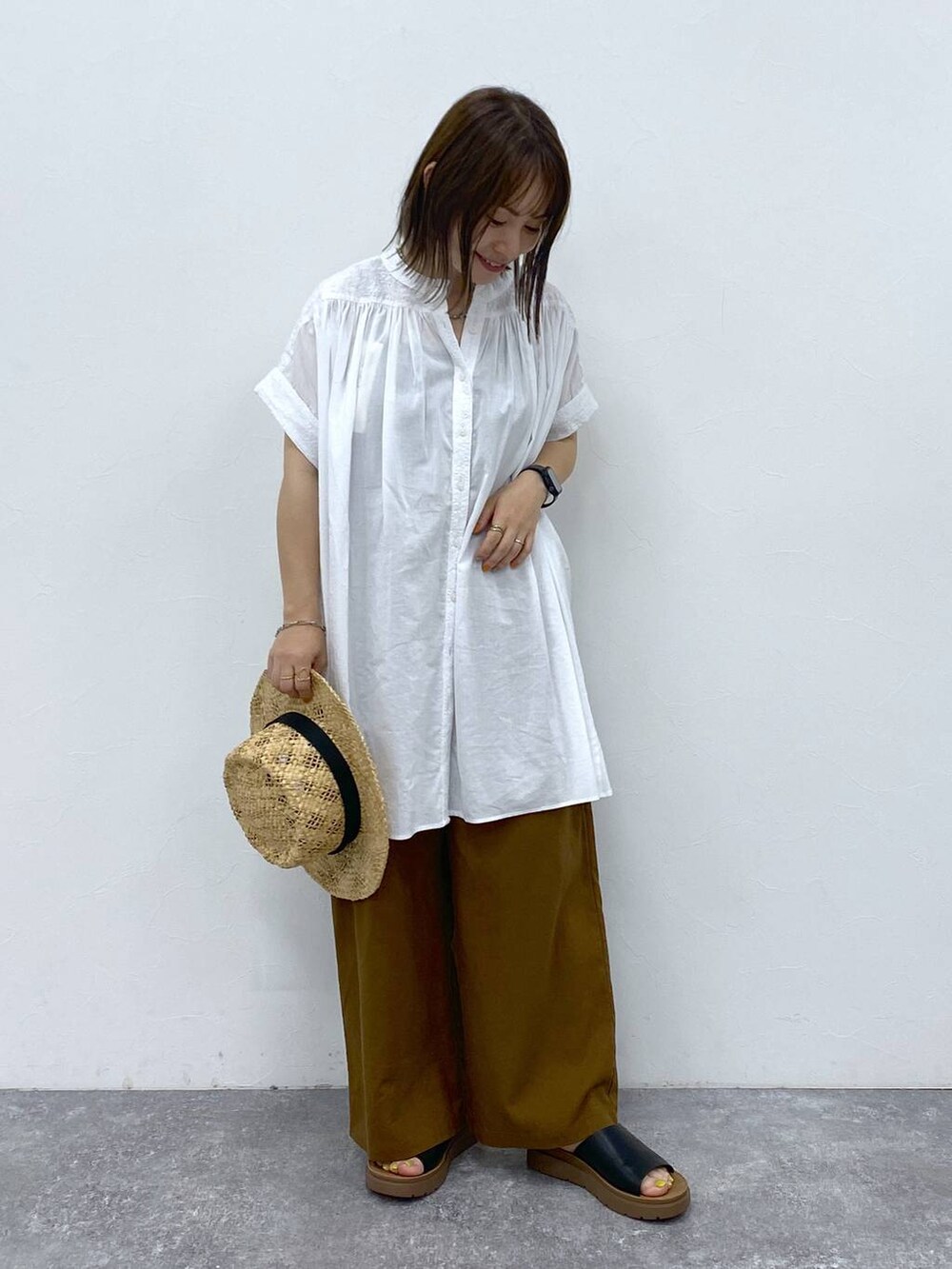 ブラウン系のその他パンツ、ブラック系のサンダル、ホワイト系のシャツ/ブラウスを着用したレディースの夏コーディネートの3枚目の写真