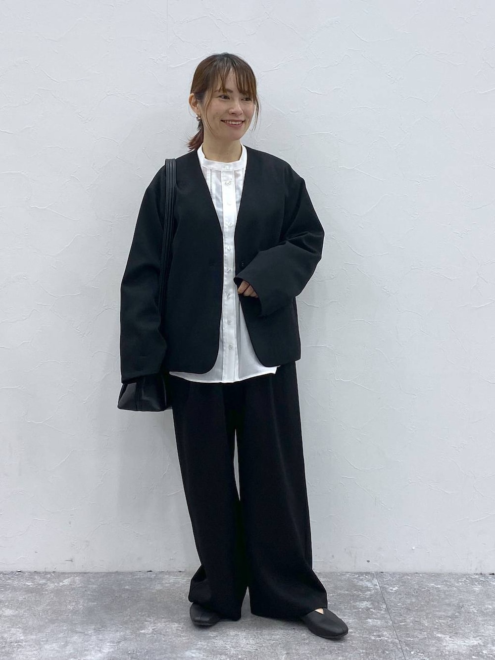 ブラック系のショルダーバッグ、ブラック系のノーカラージャケット、ホワイト系のシャツ/ブラウスを着用したレディースの冬コーディネートの2枚目の写真