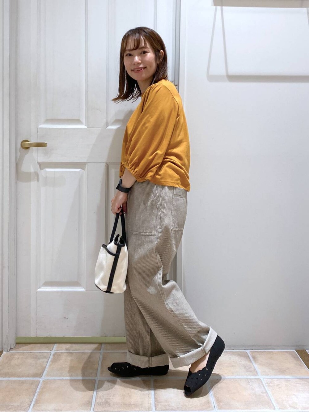 オレンジ系のTシャツ/カットソー、ブラック系のキャミソール、その他のデニムパンツを着用したレディースの夏コーディネートの5枚目の写真