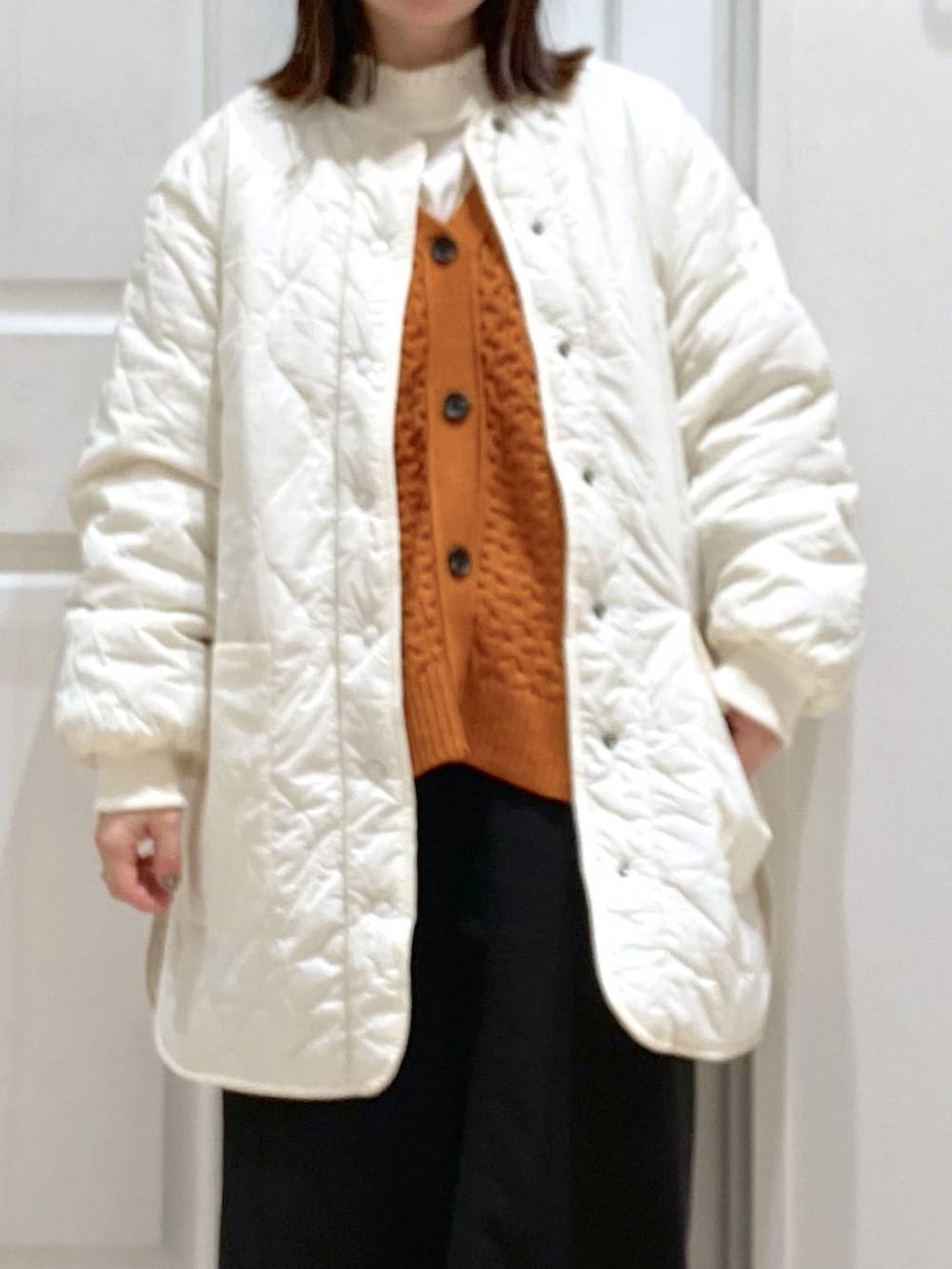 ブラック系のスカート、ホワイト系のTシャツ/カットソー、ホワイト系のノーカラーコートを着用したレディースの秋コーディネートの4枚目の写真