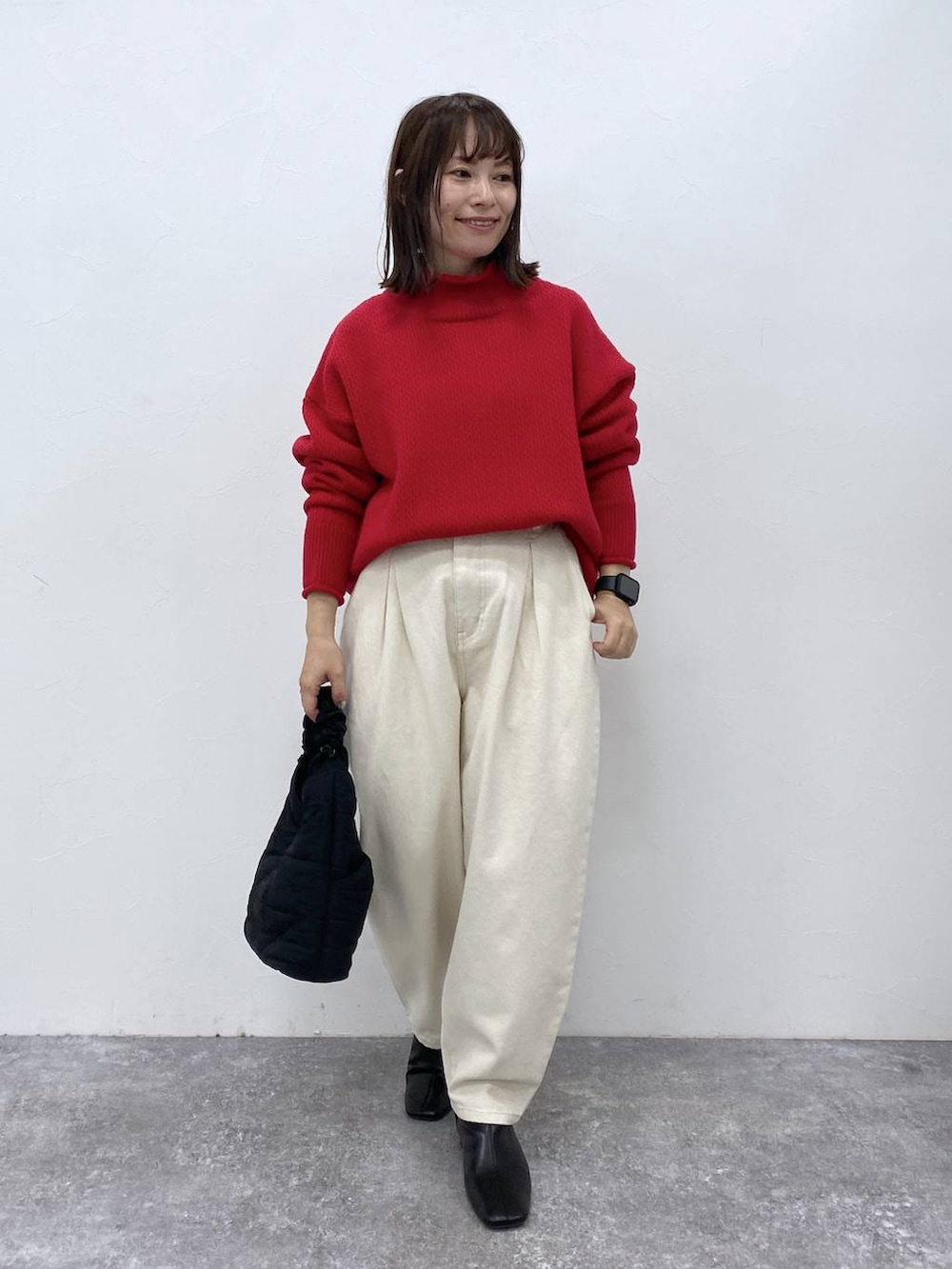 その他のニット/セーター、ブラック系のブーツ、ホワイト系のデニムパンツを着用したレディースの秋コーディネートの2枚目の写真