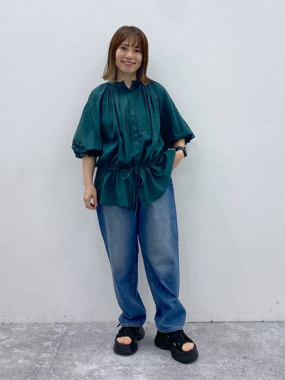 ブルー系のデニムパンツ、ブラック系のサンダル、ブラック系のタンクトップを着用したレディースの夏コーディネートの2枚目の写真