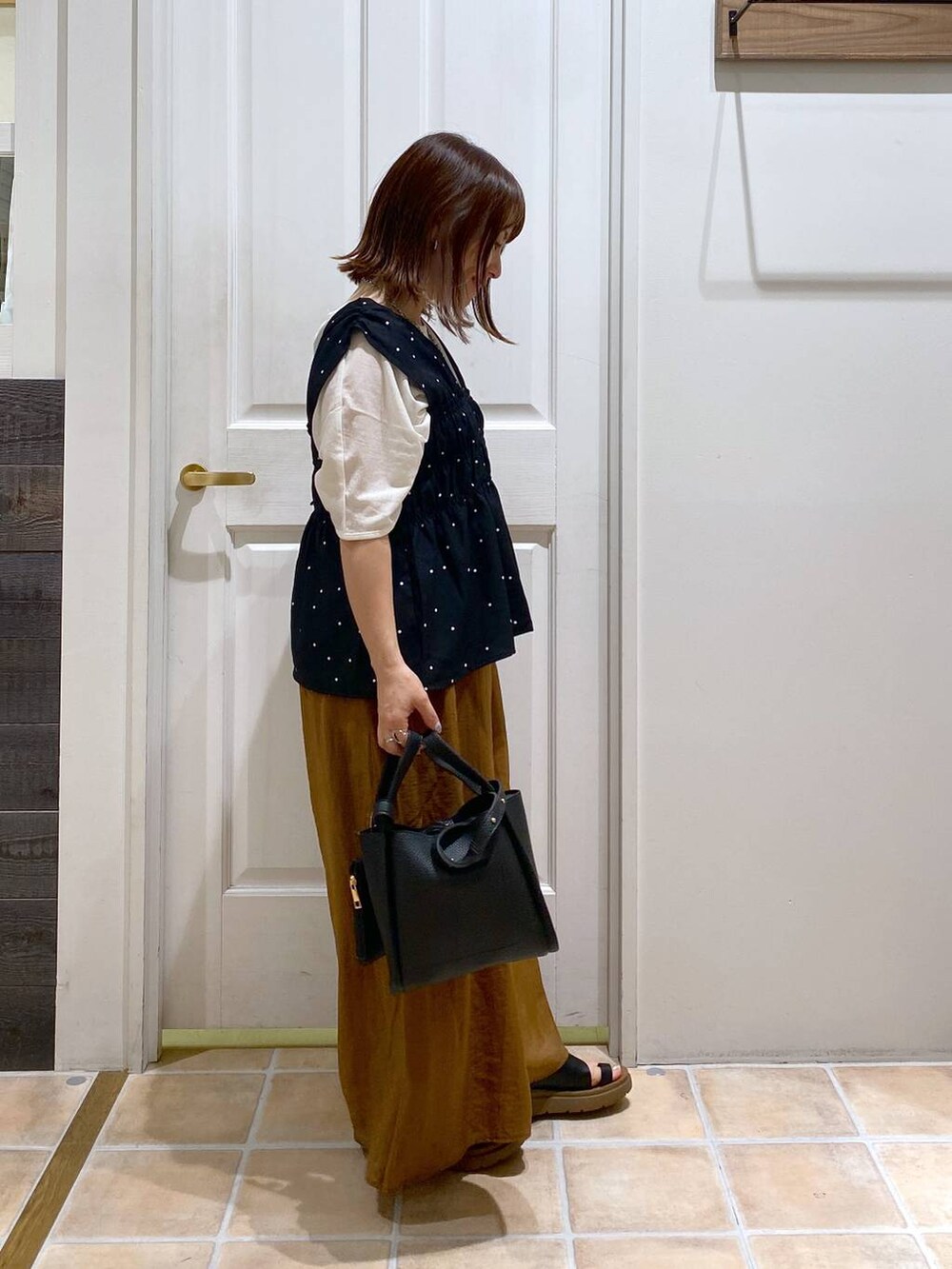 ブラック系のサンダル、ホワイト系のTシャツ/カットソー、ブラック系のショルダーバッグを着用したレディースの夏コーディネートの4枚目の写真