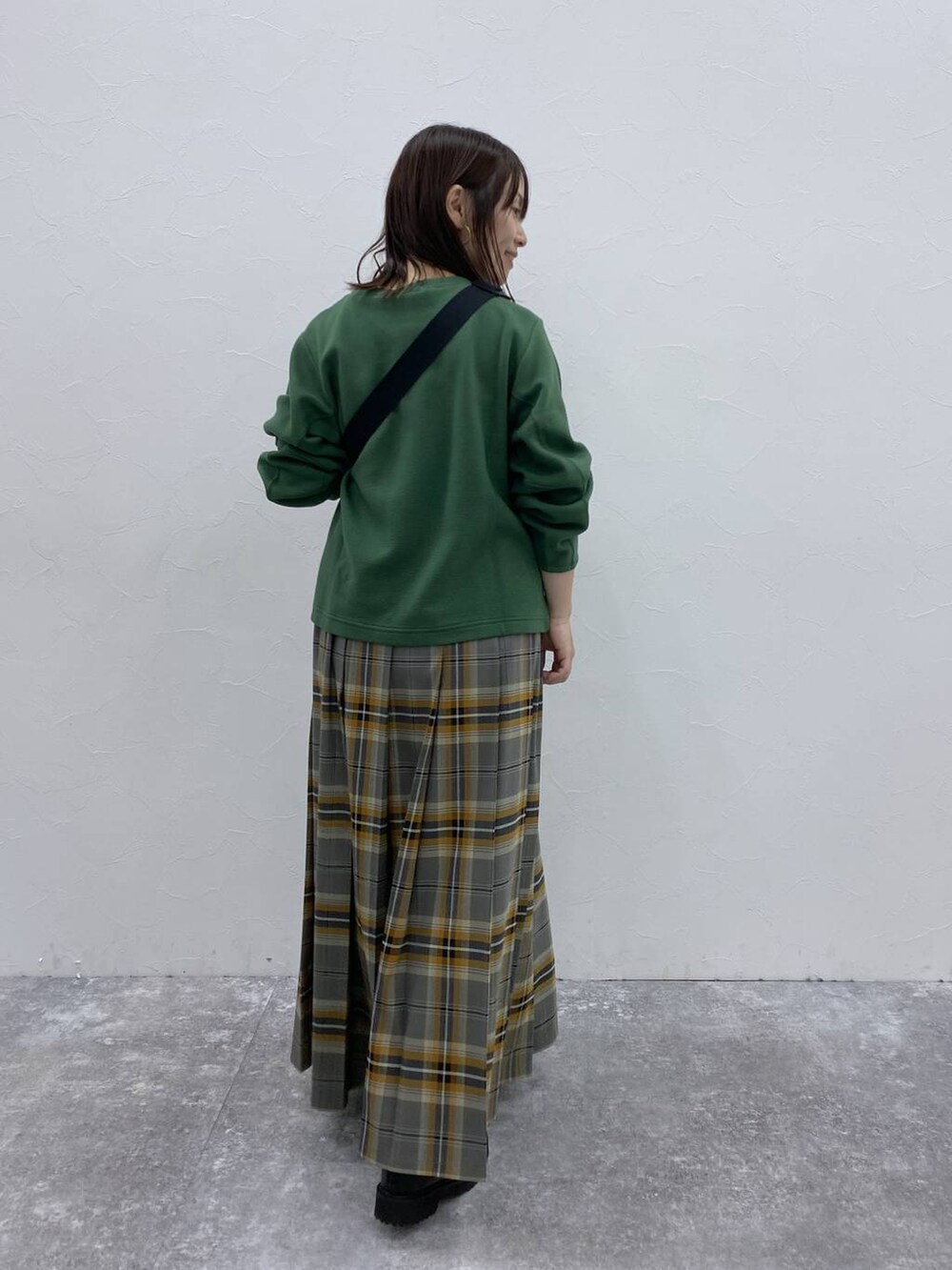 ブラック系のブーツ、ブラック系のショルダーバッグ、その他のスカートを着用したレディースの秋コーディネートの5枚目の写真