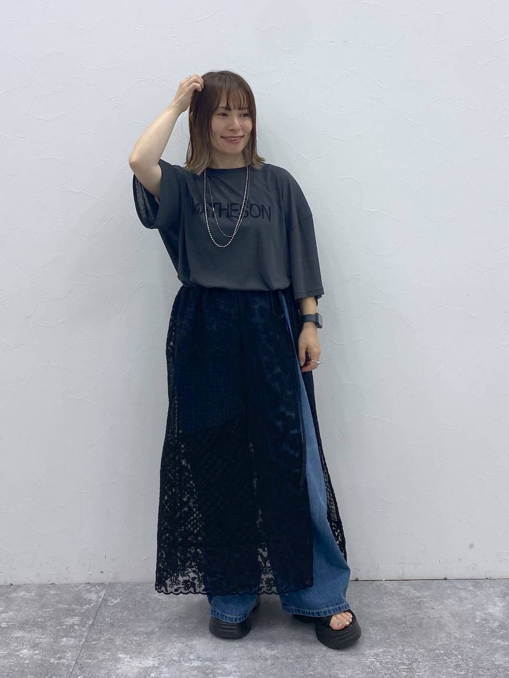 ブラック系のサンダル、ブルー系のデニムパンツ、ブラック系のスカートを着用したレディースの秋コーディネートの3枚目の写真