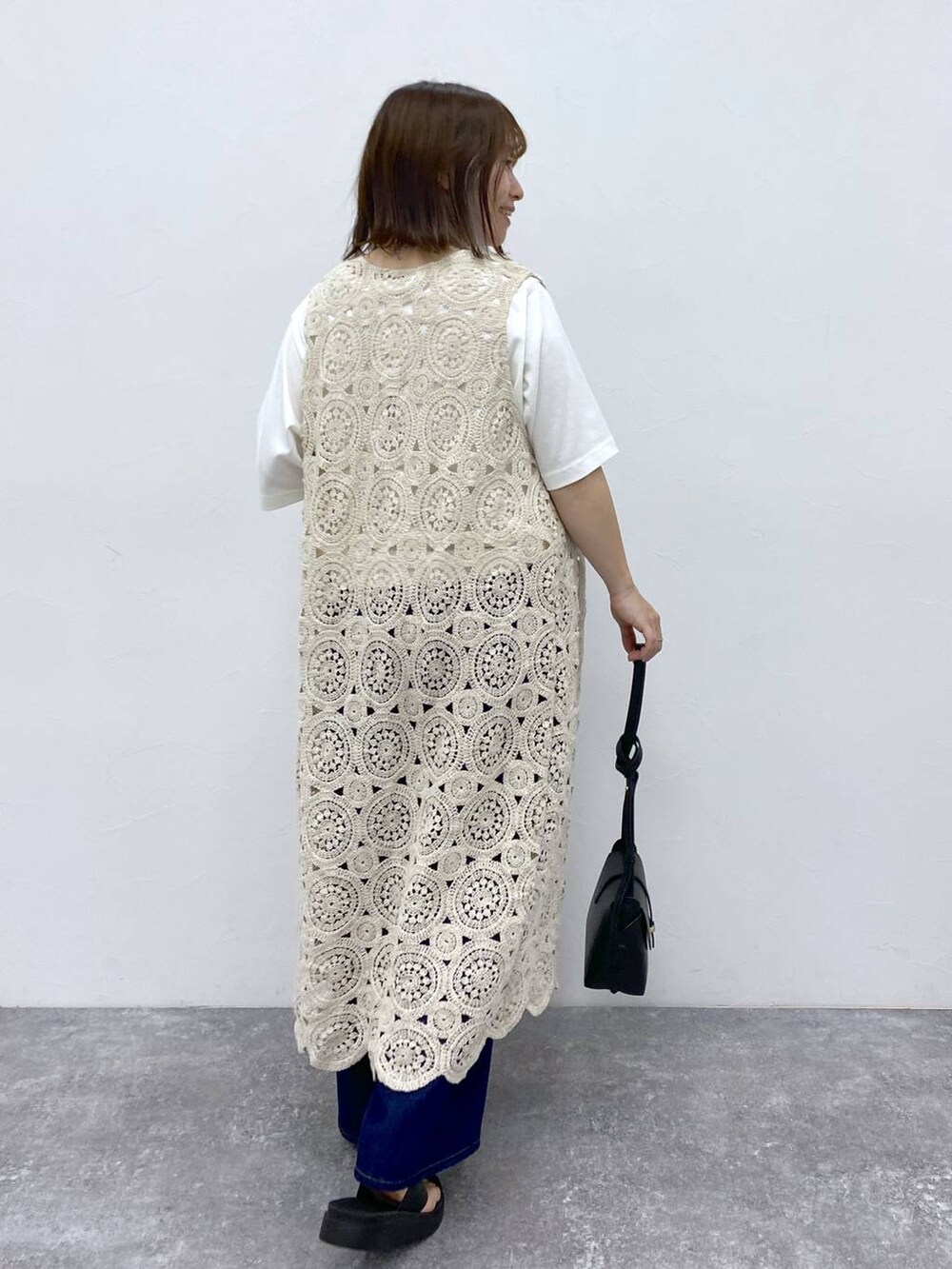 ブラック系のサンダル、ホワイト系のTシャツ/カットソー、ブラック系のショルダーバッグを着用したレディースの夏コーディネートの6枚目の写真