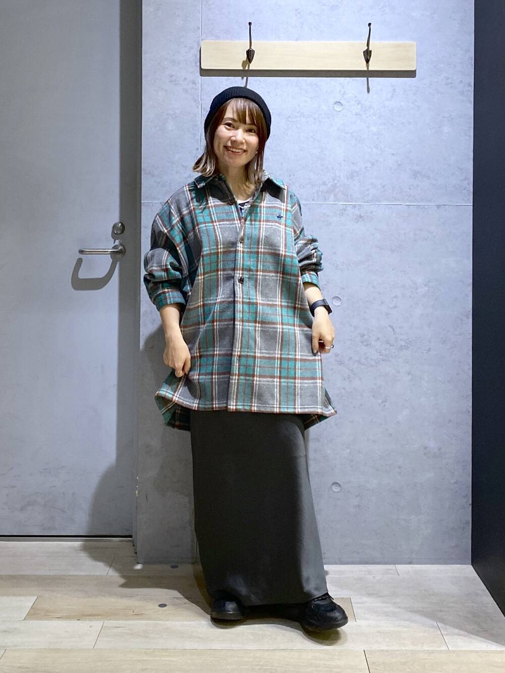 グレー系のスカート、ブラック系のスニーカー、グレー系のシャツ/ブラウスを着用したレディースの秋コーディネートの3枚目の写真