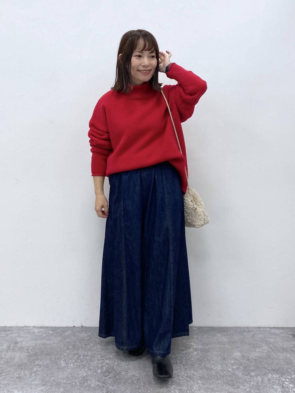 ブルー系のデニムパンツ、ブラック系のブーツを着用したレディースの秋コーディネートの4枚目の写真