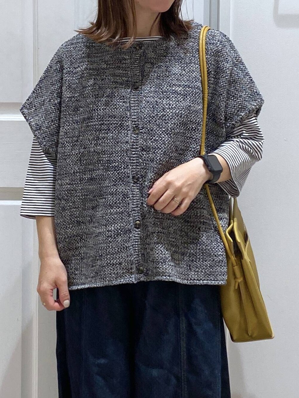 ブルー系のデニムパンツ、ブラック系のドレスシューズ、イエロー系のショルダーバッグを着用したレディースの夏コーディネートの5枚目の写真