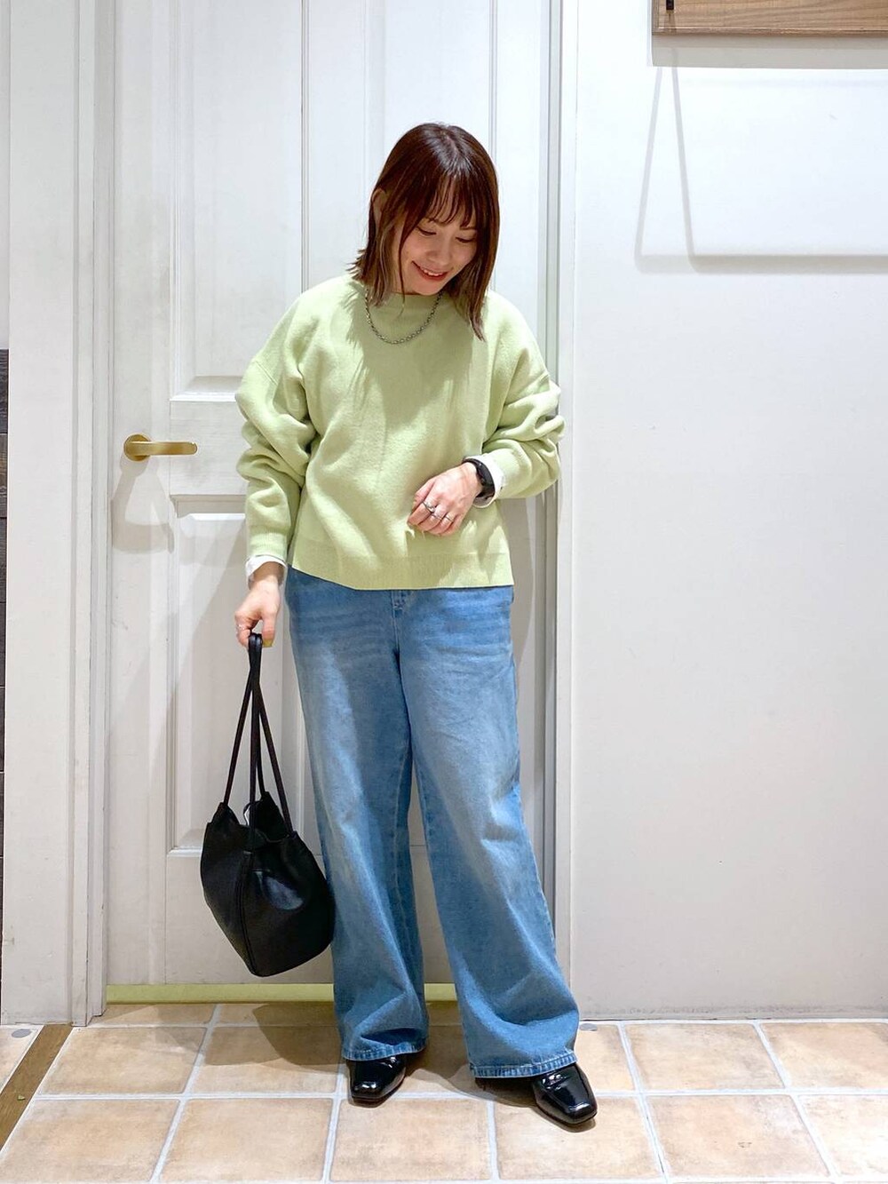 ブラック系のローファー、ブルー系のデニムパンツ、ホワイト系のTシャツ/カットソーを着用したレディースの春コーディネートの2枚目の写真