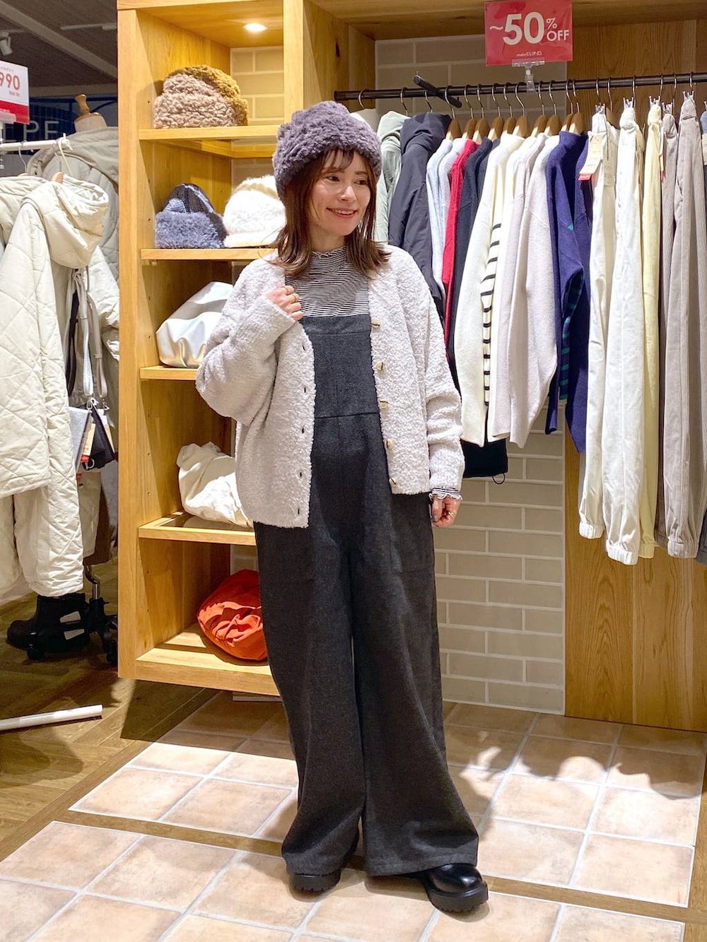 ブラック系のブーツ、グレー系のカーディガン/ボレロ、その他のTシャツ/カットソーを着用したレディースの冬コーディネートの2枚目の写真