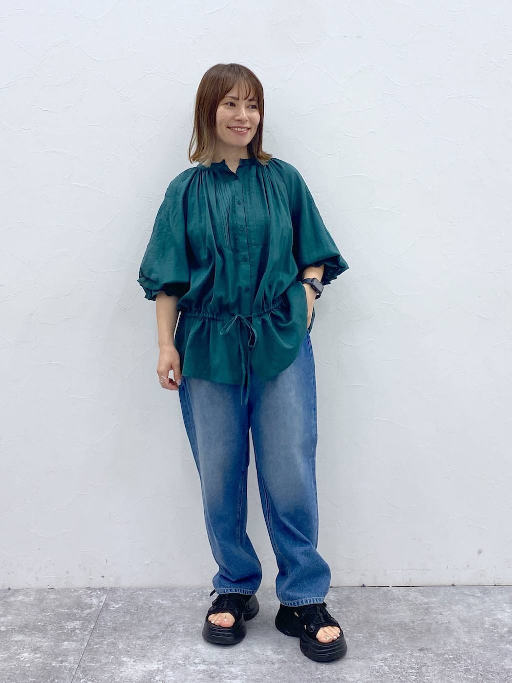 ブルー系のデニムパンツ、ブラック系のサンダル、ブラック系のタンクトップを着用したレディースの夏コーディネートの3枚目の写真