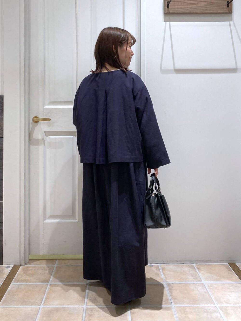 ブラック系のパンプス、ブルー系のセットアップ、その他のピアス（両耳用）を着用したレディースの冬コーディネートの7枚目の写真