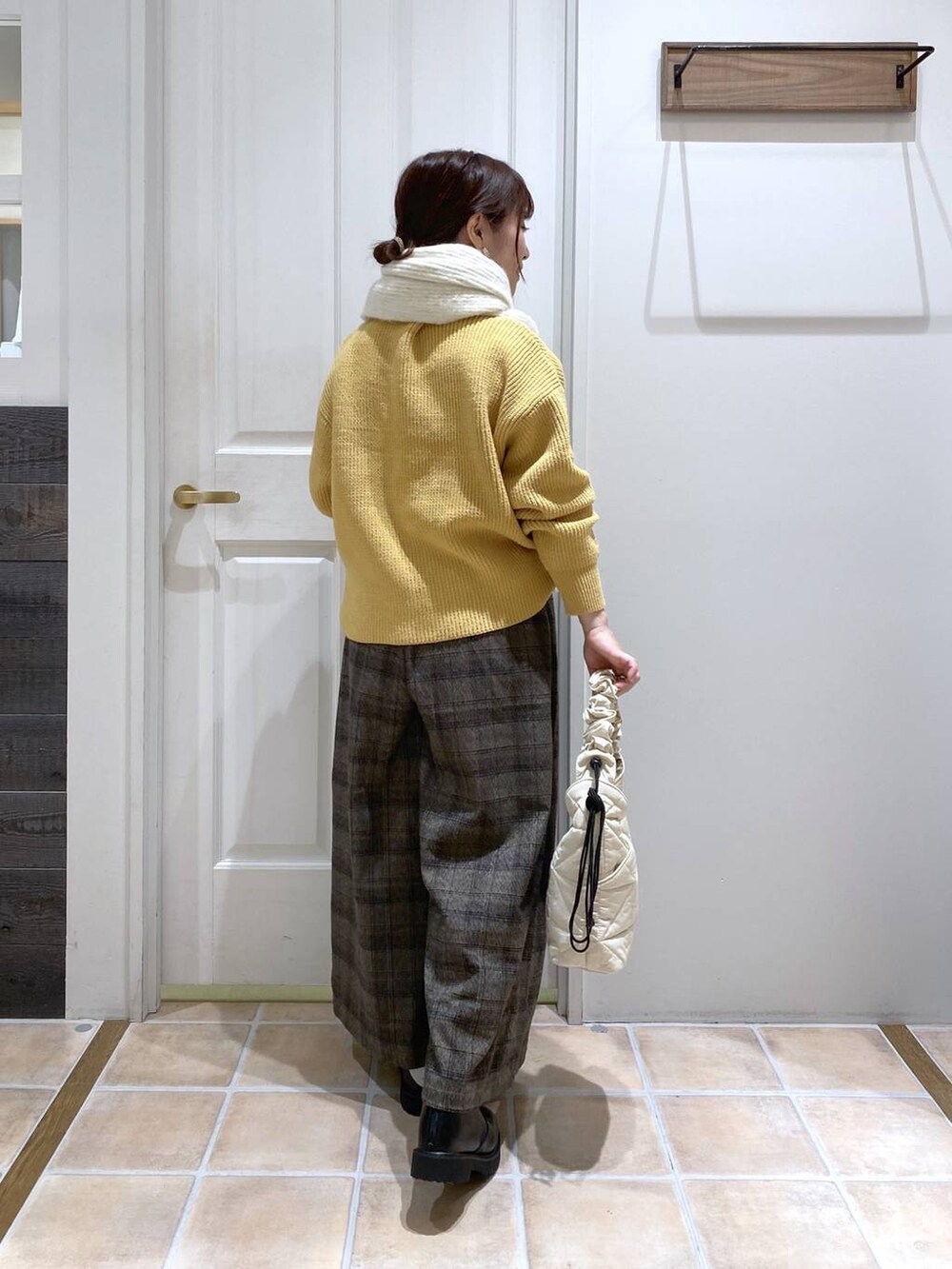 イエロー系のニット/セーター、その他のその他パンツ、ベージュ系のトートバッグを着用したレディースの秋コーディネートの5枚目の写真