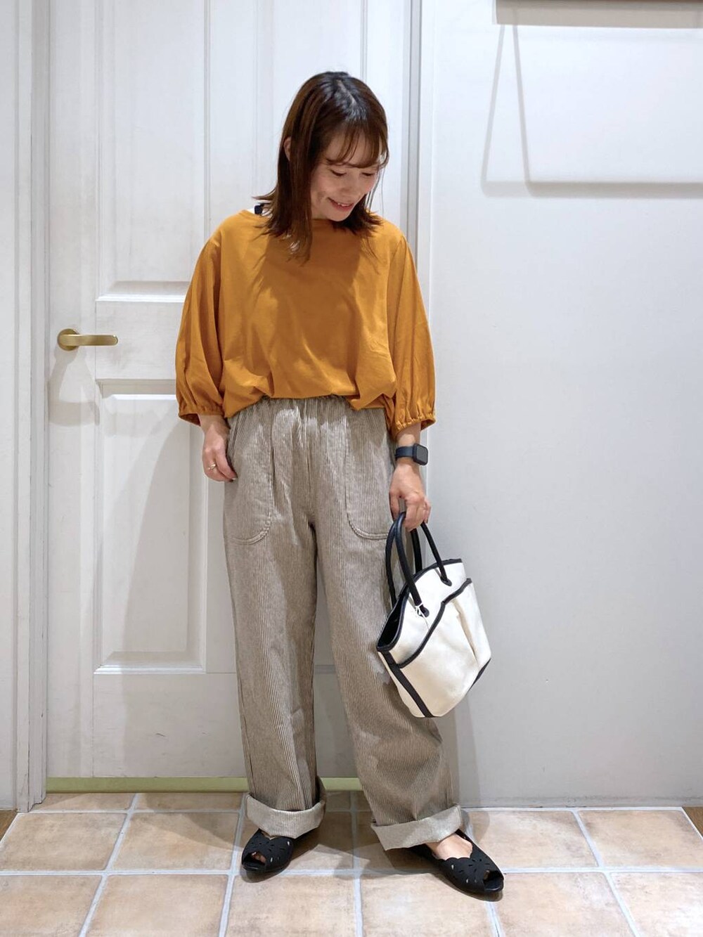 オレンジ系のTシャツ/カットソー、ブラック系のキャミソール、その他のデニムパンツを着用したレディースの夏コーディネートの4枚目の写真