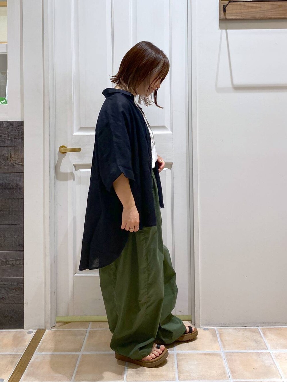 ブラック系のサンダル、ブラック系のシャツ/ブラウス、その他のTシャツ/カットソーを着用したレディースの夏コーディネートの3枚目の写真