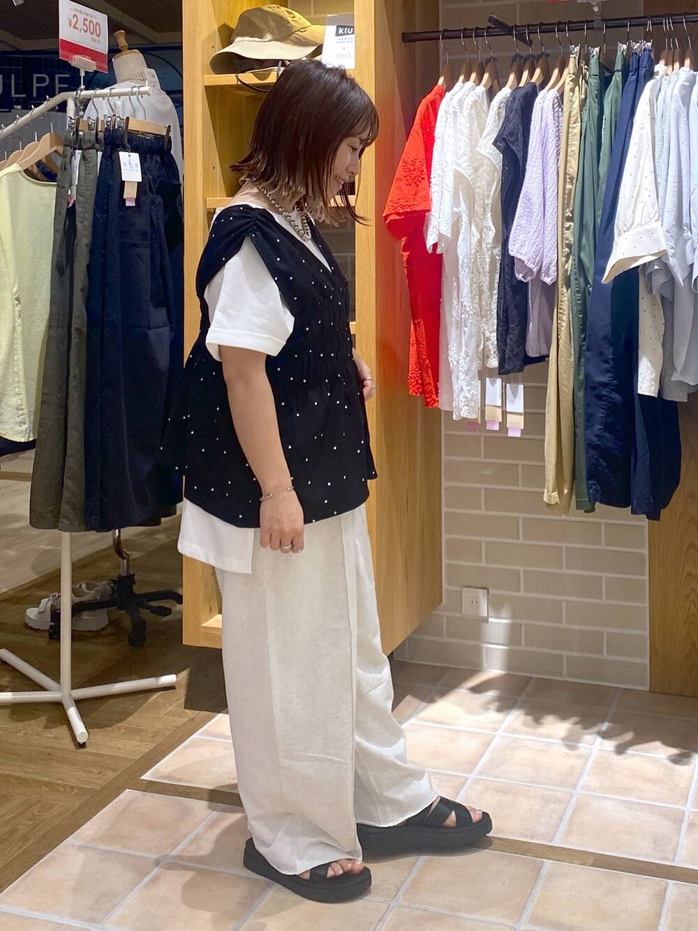 ブラック系のサンダル、ブラック系のその他パンツ、ホワイト系のTシャツ/カットソーを着用したレディースの夏コーディネートの4枚目の写真