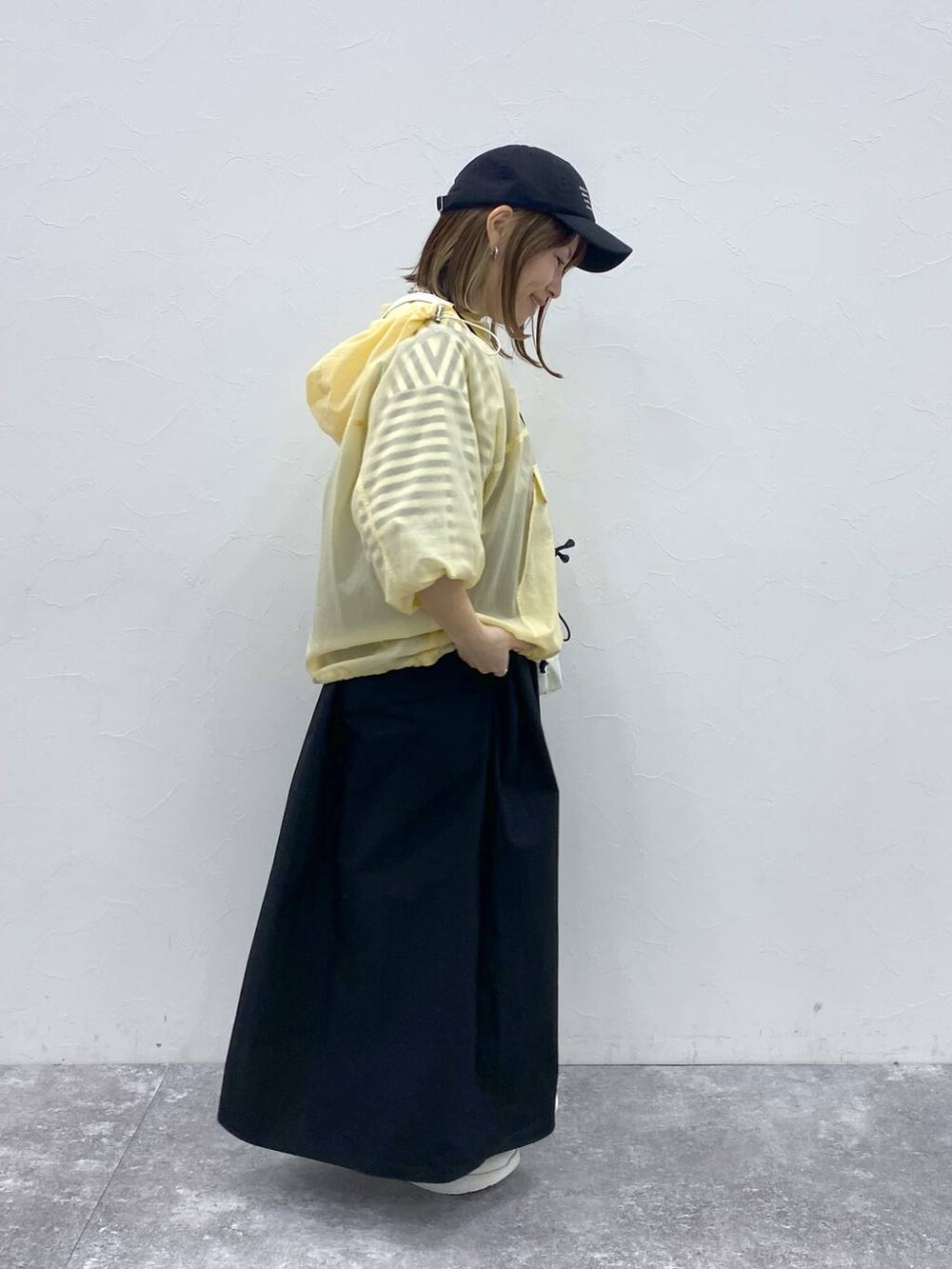 ホワイト系のスニーカー、ブラック系のキャップ、ホワイト系の財布を着用したレディースの春コーディネートの4枚目の写真